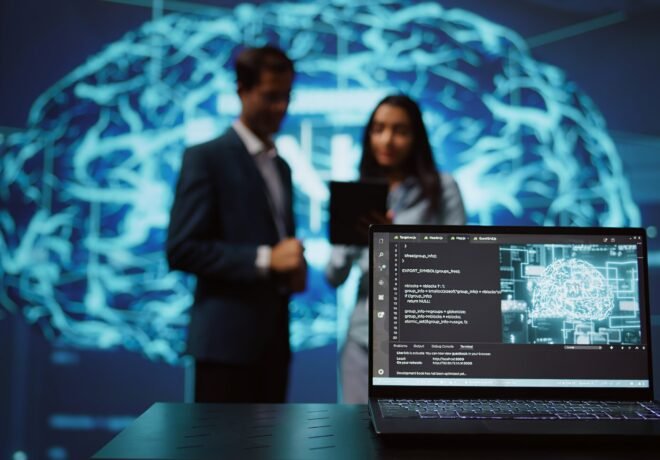 Focus on laptop in workspace used by AI researchers working with artificial intelligence in blurry background. Close up of notebook used by employees developing AI systems in tech startup, camera B